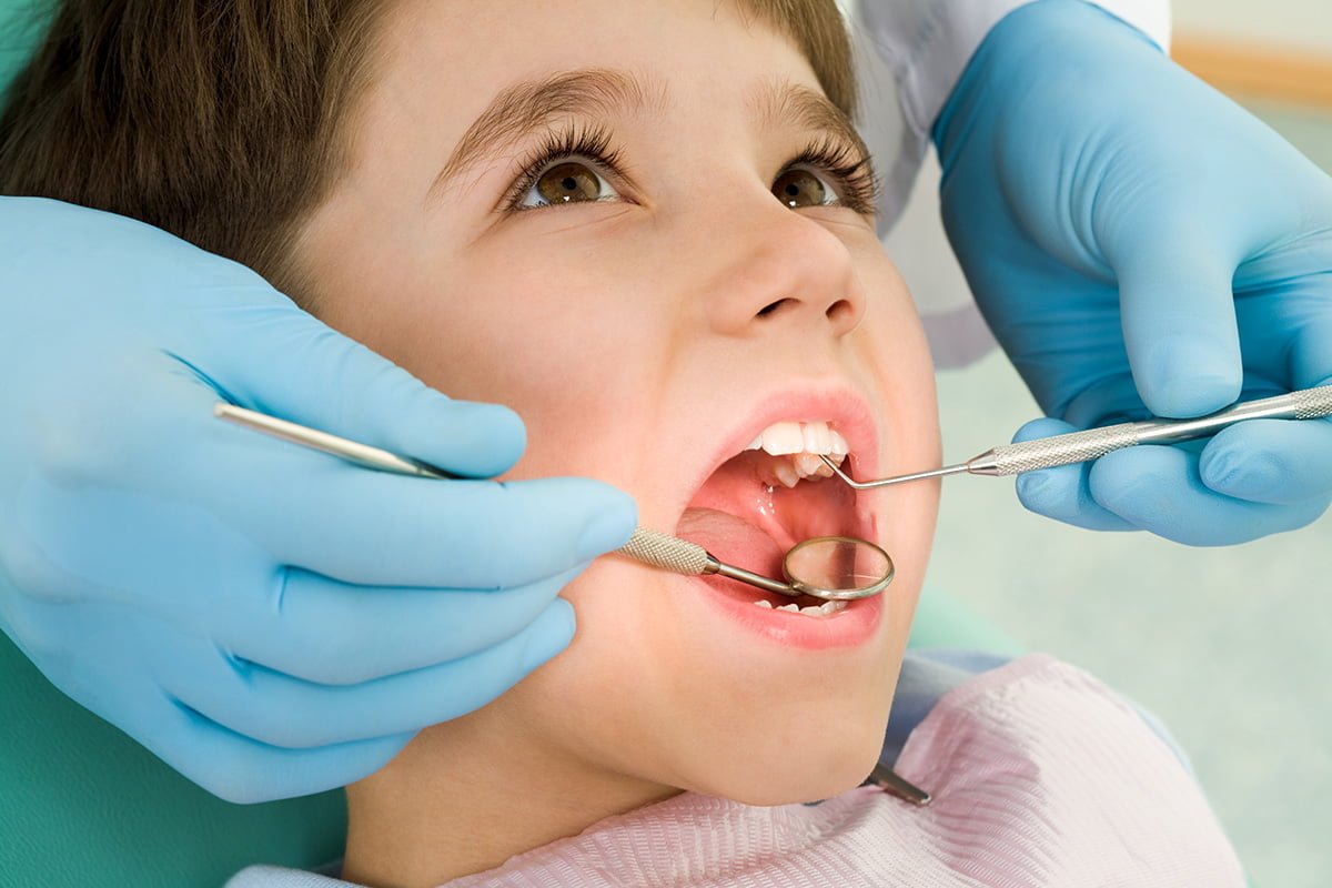 Pediatric dentist examining a child patient's teeth